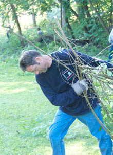 Pete Browne dragging some honeysuckle canes to the curb.