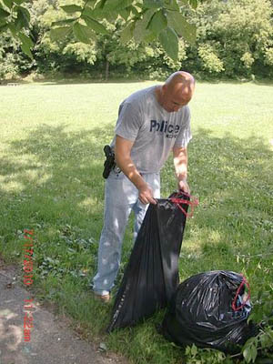 Officer Sean Finn is really involved in looking after our neighborhood. Officer Finn, who is just back from his third tour in Iraq/Aghanistan and patrols Central Division, brought a community service crew to the park Saturday morning. Later in the day he even returned in uniform and patrol car to check the progress and see how we judged the work of the crew. He’s apparently as inspiring in telling a story as is the story about his illustrious career. The community service men and women were inspired by Officer Finn to work their tails off and helped make the huge dent in the honeysuckle you can see today.